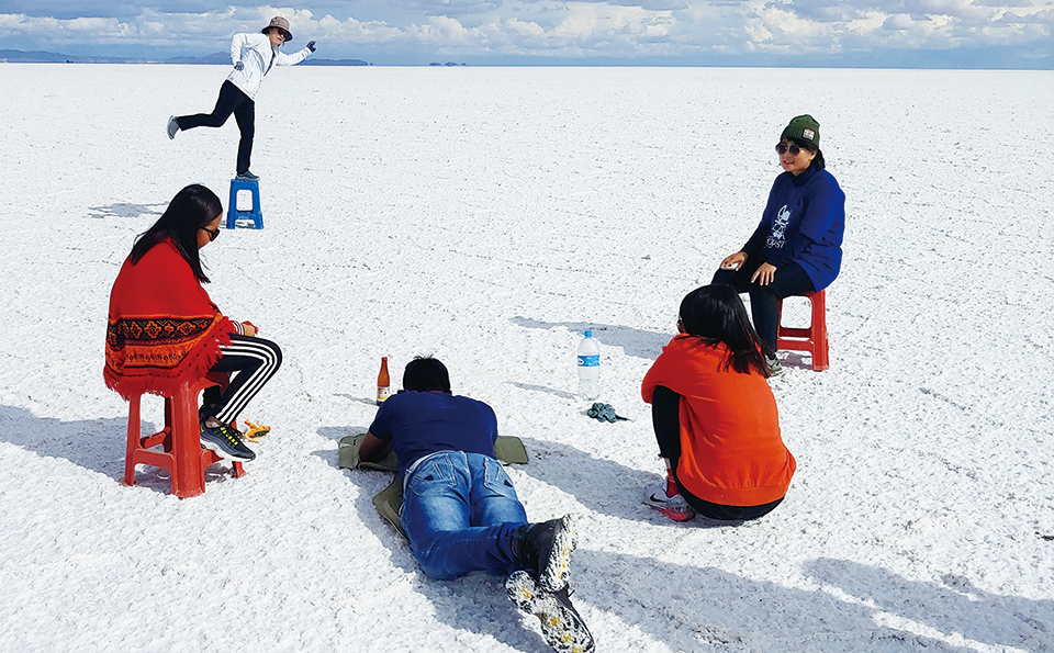 소금 사막에서 사진 찍기 놀이를 즐기는 여행자들