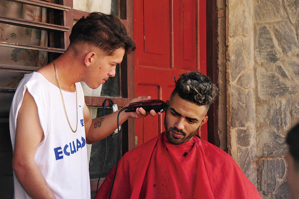 거리의 이발사. 이발사도 손님도 진지하다.
