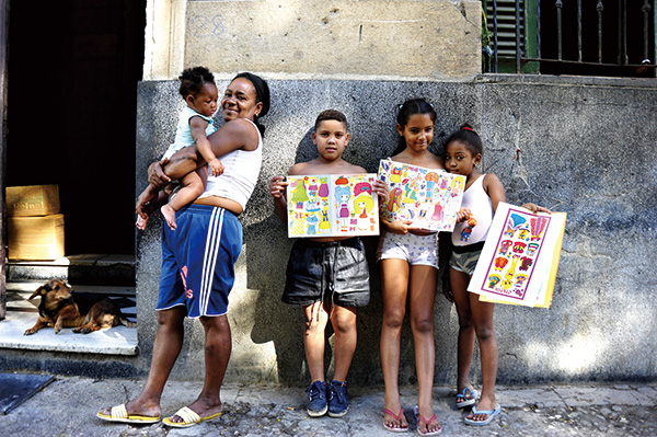 한국에서 가져간 종이 인형을 받고  사진을 찍고 있는 동네 아이들
