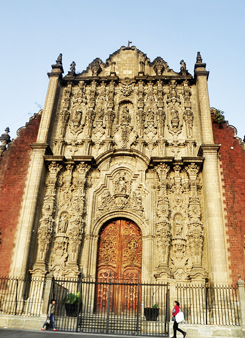 웅장하고 화려한 외관의 성당 앞을 지나는 사람. 유난히 작아 보인다