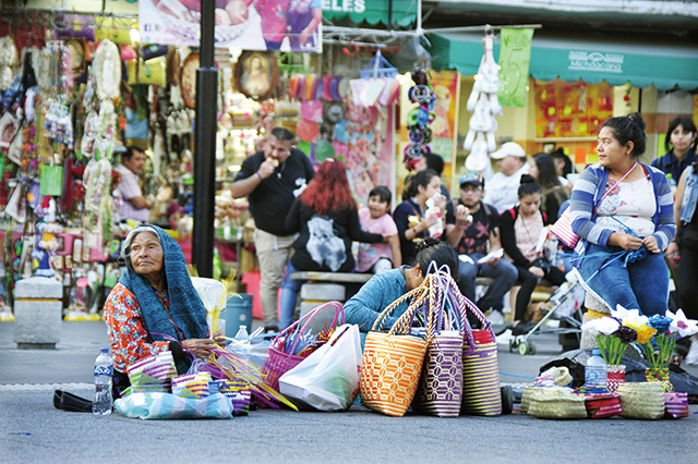 인디오들의 행진소리에 시선을 빼앗긴 채 손으로는 가방을 만들고 있는 할머니