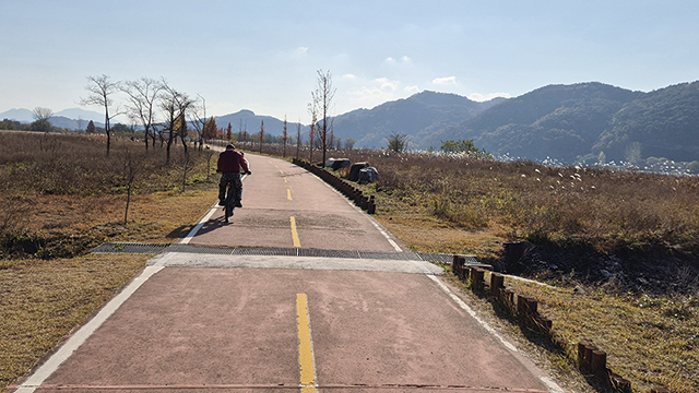 산책로에서 자전거를 타고 가는 사람