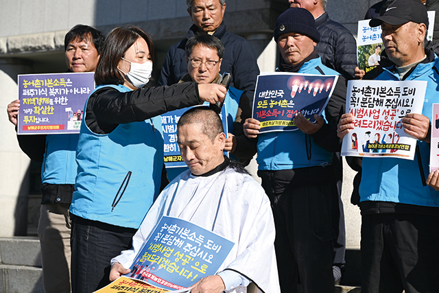 류경완 도의원(남해)이 지난해 12월 도의회 예산결산특별위원회가 열린 의회 앞에서 상임위원회가 삭감한 남해군 농어촌 기본소득 도비 126억 원 복원을 요청하며 삭발을 하면서 눈물을 흘리고 있다